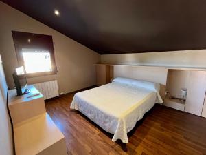 a small bedroom with a bed and a window at Can Morera Apartaments a Les Preses in Les Preses