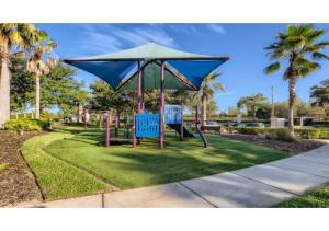 un parque con dos sillas azules y una sombrilla en Amazing Aviana 5BR Resort Pool Home Near Disney World, en Davenport