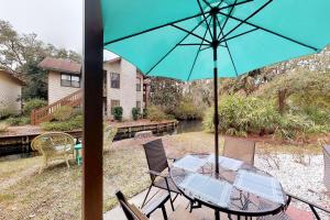 ein Tisch und Stühle mit einem Sonnenschirm auf einer Terrasse in der Unterkunft Harbour Oaks, Unit 213 in Demere Park