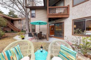 eine Terrasse mit 2 Stühlen, einem Tisch und einem Sonnenschirm in der Unterkunft Harbour Oaks, Unit 213 in Demere Park