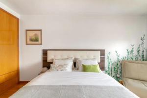 1 dormitorio con 1 cama blanca grande con almohadas verdes en Apartamento da Praça, en Oporto