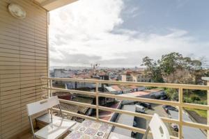 uma varanda com um banco e vista para a cidade em Apartamento da Praça no Porto