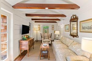 un salon avec un canapé et une télévision dans l'établissement Gull Guest Cottage - 757 Ocean Blvd, à Saint Simons