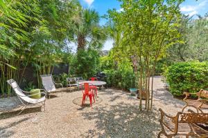 un patio avec une table, des chaises et des arbres dans l'établissement Gull Guest Cottage - 757 Ocean Blvd, à Saint Simons