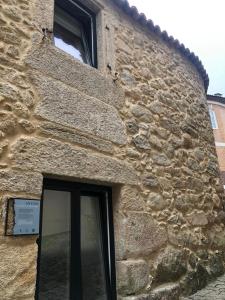 un edificio de piedra con una ventana en el lateral. en Casa Arrabal, en Oia