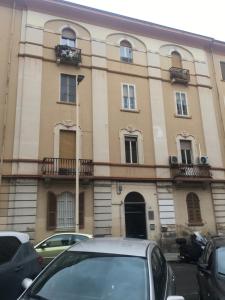 un bâtiment avec des voitures garées devant lui dans l'établissement CASACRIZIA, à Cagliari