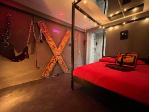 a bedroom with a bed with a x sign on the wall at Les 50 nuances de rouge LOVEROOM in Souppes-sur-Loing