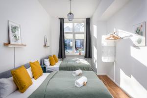 two beds in a room with yellow and green at Sonnig und Helle Wohnung Alexanderplatz in 15min zu erreichen, sehr schön und groß für Gruppen geeignet in Berlin