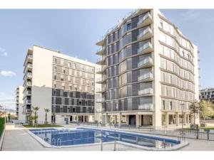 um edifício de apartamentos com uma piscina em frente em Apartamento de diseño con Gym y Piscina em Castellón de la Plana