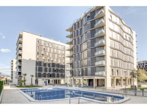 ein Mehrfamilienhaus mit einem Pool davor in der Unterkunft Apartamento de diseño con Gym y Piscina in Castellón de la Plana