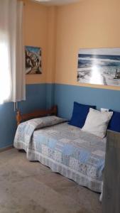 a bedroom with a bed and a painting on the wall at Precioso piso en la playa in El Puerto de Santa María