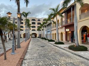 eine Kopfsteinpflasterstraße mit Palmen vor einem Gebäude in der Unterkunft hotel DUCASSI Sol Cariba Punta Cana in Punta Cana