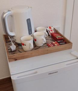 una mensola sopra un frigorifero con tre tazze di caffè di Barba Ante a Vis