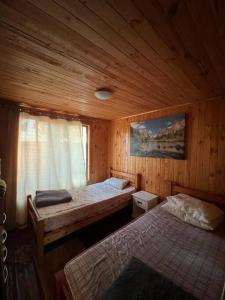 um quarto com 2 camas num chalé de madeira em Parcela de agrado orilla de lago em El Estero
