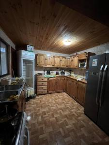uma cozinha com armários de madeira e um frigorífico em Parcela de agrado orilla de lago em El Estero