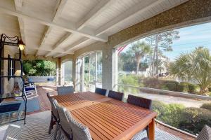 a screened in porch with a wooden table and chairs at A Wave From It All - 811 Ocean Blvd in Saint Simons