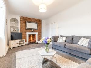 a living room with a couch and a fireplace at Church View in Hunstanton