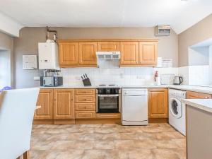 a kitchen with wooden cabinets and white appliances at Church View in Hunstanton