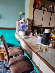 una cocina con 2 sillas sentadas en un mostrador en The Cozy Cactus House Cartago Centro English Spoke, en Cartago