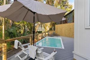 a patio with an umbrella and two chairs and a pool at Village Walk - 104 Mews Circle in King City