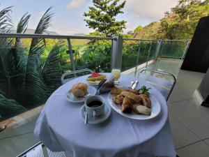 ein Tisch mit einem Teller Essen und einer Tasse Kaffee in der Unterkunft Hotel Floresta do Carajas in Parauapebas
