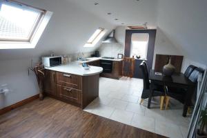 a kitchen with a sink and a table with a desk at Belfast Loft in Belfast