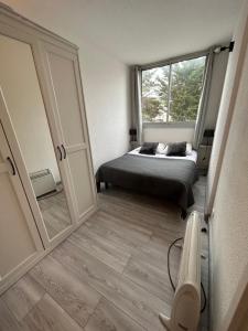 - une chambre avec un lit et un grand miroir dans l'établissement Petit T2 proche de la plage, à Sète