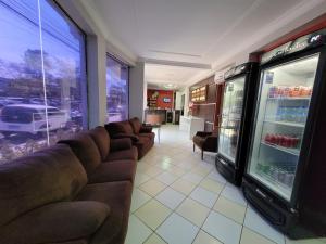 a living room with a couch and a refrigerator at Hotel Floresta do Carajas in Parauapebas