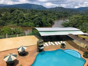 a resort with a swimming pool and a river at Hotel Floresta do Carajas in Parauapebas