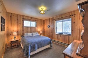 una camera da letto con pareti in legno, un letto e una finestra di Star Valley Ranch Cabin Getaway Hot Tub! a Thayne