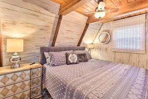 1 dormitorio con 1 cama y pared de madera en Lake Hamilton Cabin Boating Getaway!, en Hot Springs