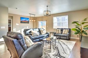 a living room with two leather couches and a table at Spacious Aurora House with Yard about 10 Mi to DIA! in Aurora