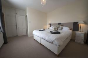 una camera da letto con un grande letto con lenzuola e cuscini bianchi di Buzzard's Reach formerly Rose Loft Coniston a Coniston