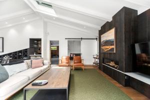 a living room with a couch and a tv at Lavish at the Lake in Taupo
