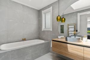 a bathroom with a tub and a sink at Lavish at the Lake in Taupo +18 photos