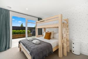 a bedroom with a bunk bed and a balcony at Lavish at the Lake in Taupo