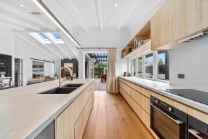 a large kitchen with wooden cabinets and a sink at Lavish at the Lake in Taupo