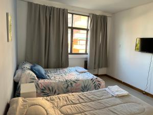 a hotel room with two beds and a window at Plaza Independencia in Mendoza