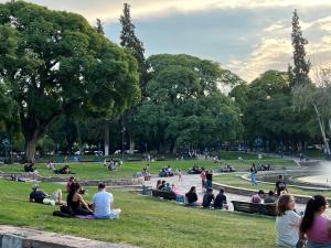 un grupo de personas sentadas en el césped en un parque en Plaza Independencia 2023 en Mendoza
