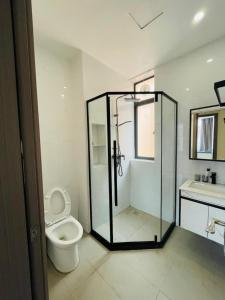 ein Bad mit einer Dusche, einem WC und einem Waschbecken in der Unterkunft GolfHill Apartment in Kigali
