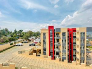 ein Apartmenthaus mit roten Säulen auf einem Parkplatz in der Unterkunft GolfHill Apartment in Kigali