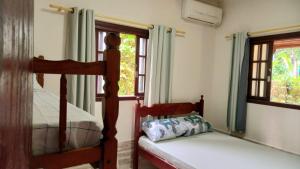 a bedroom with two bunk beds and a window at Casas Jacatirão in Ubatuba