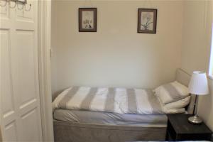 a small bedroom with a bed and two pictures on the wall at Moleside Cottage in Marden