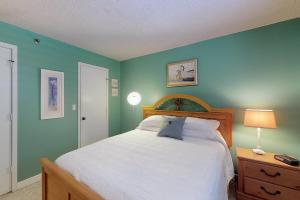 1 dormitorio con 1 cama grande y paredes azules en North Breakers - Unit 202, Wood Ave, en East End
