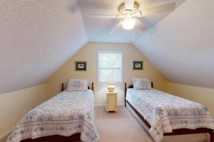 Schlafzimmer im Dachgeschoss mit 2 Betten und einem Deckenventilator in der Unterkunft Coastal Cottage - 111 Mews Circle in King City