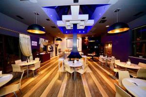 a restaurant with tables and chairs and a chandelier at Sani Polyastron Hotel & Spa in Sani Beach