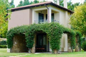 a white house with an ivy covered entry way at Sani Polyastron Hotel & Spa in Sani Beach