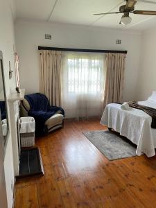 ein Wohnzimmer mit einem Bett und einem Sofa in der Unterkunft Repose Guest house! in King Williamʼs Town