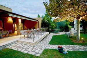 a patio with a table and chairs in a yard at Sani Polyastron Hotel & Spa in Sani Beach