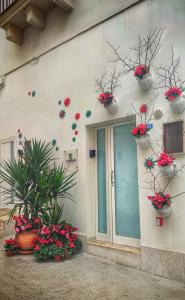 un edificio con macetas de flores a un lado. en La Nghioscia, en Grottaglie